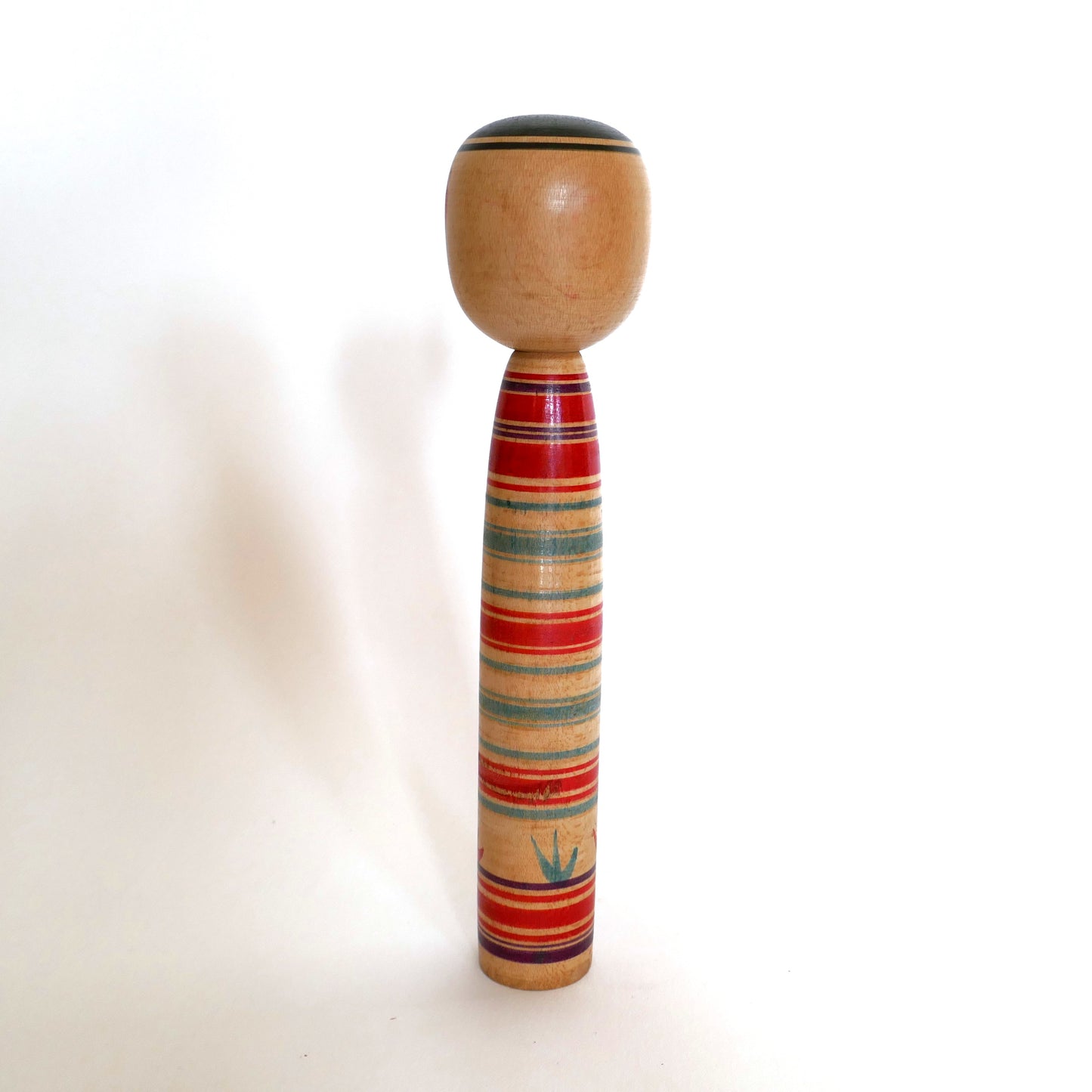 Vue de dos d’une poupée kokeshi traditionnelle Tsuchiyu, artisanat en bois tourné signé Watanabe Sadami, Japon.