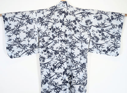 Dos d’un yukata japonais blanc et bleu à motifs répétés de momiji, feuilles de bambou et fleurs japonaises
