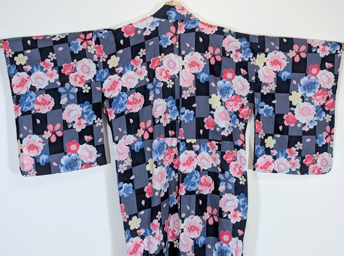 Vue de dos d’un yukata japonais en coton avec manches traditionnelles, fleurs sakura et damier gris noir