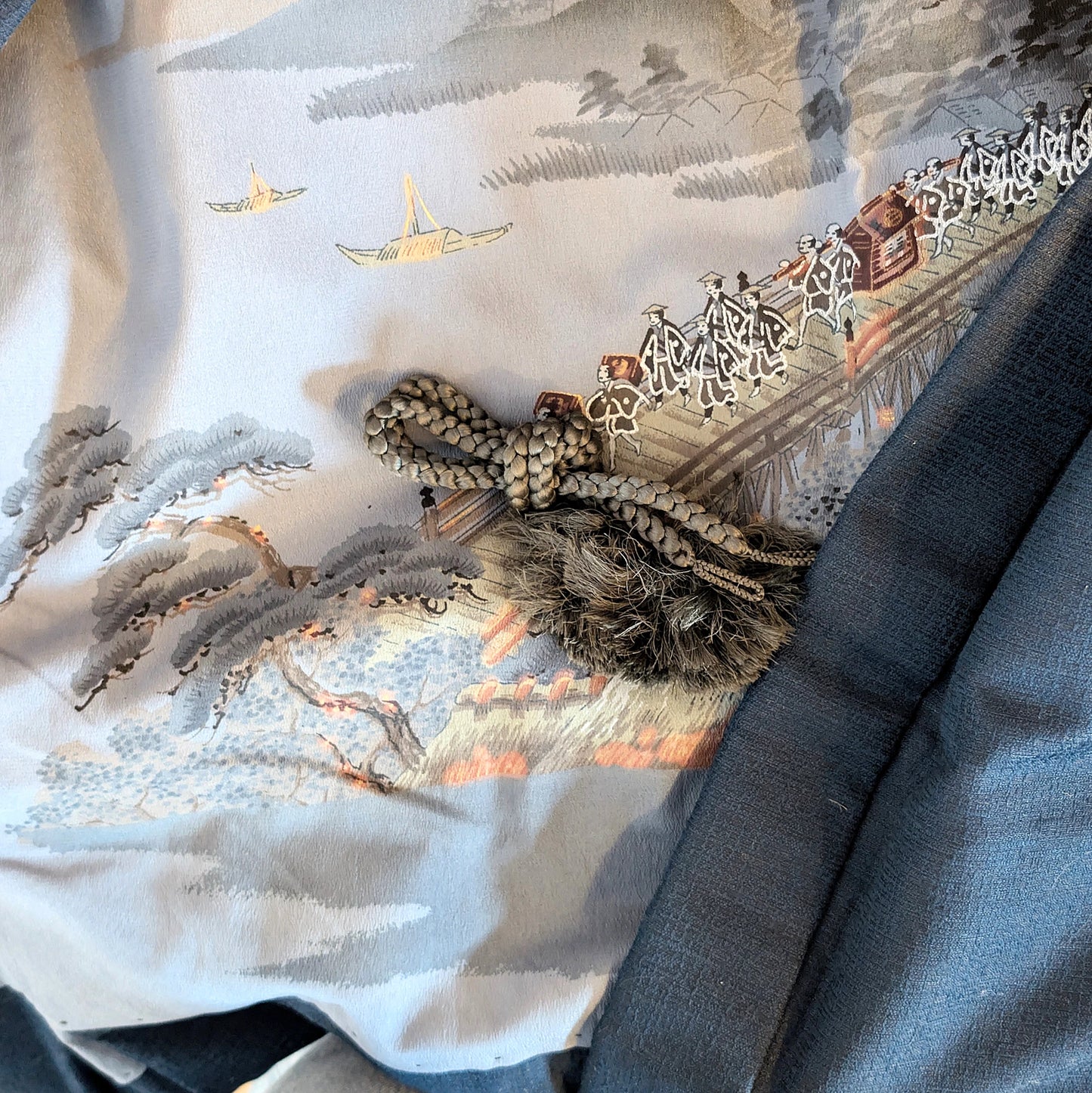 Détail de la doublure ukiyo-e d’un haori japonais avec cordon décoratif traditionnel haori himo, scène ancienne avec pont et procession