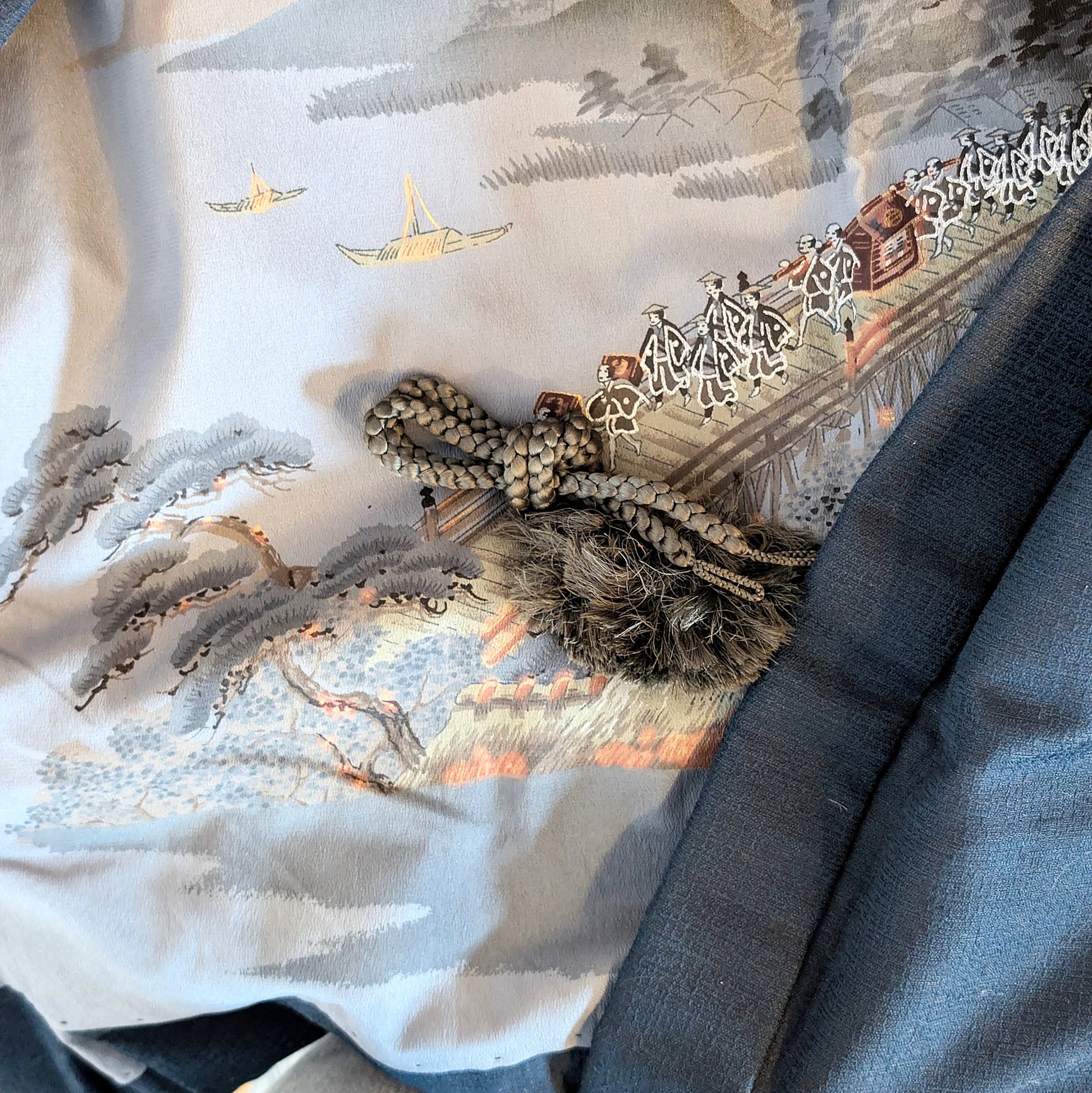 Détail de la doublure ukiyo-e d’un haori japonais avec cordon décoratif traditionnel haori himo, scène ancienne avec pont et procession