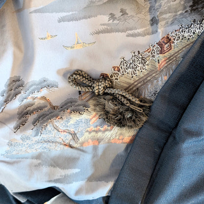 Détail de la doublure ukiyo-e d’un haori japonais avec cordon décoratif traditionnel haori himo, scène ancienne avec pont et procession
