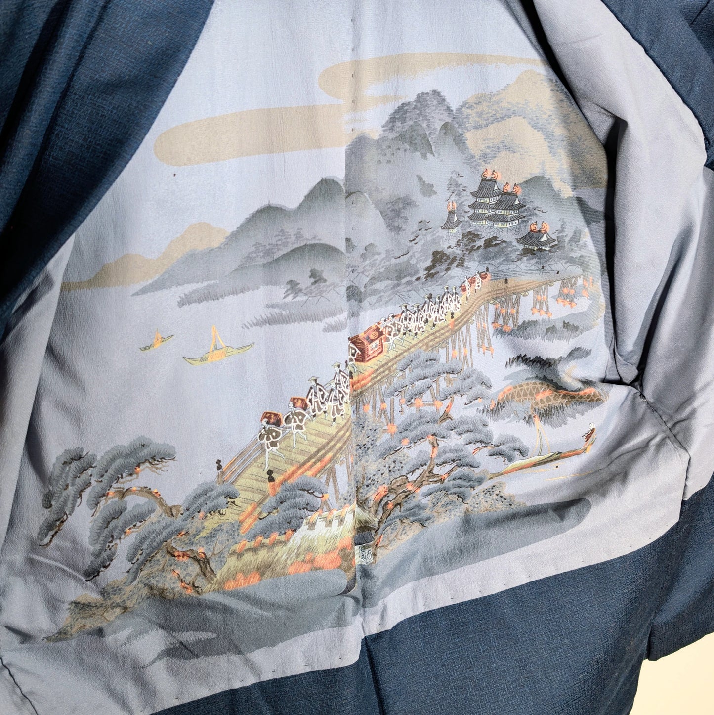Doublure intérieure d’un haori japonais homme illustrée d’une scène ukiyo-e avec pont, château japonais, montagne et procession traditionnelle
