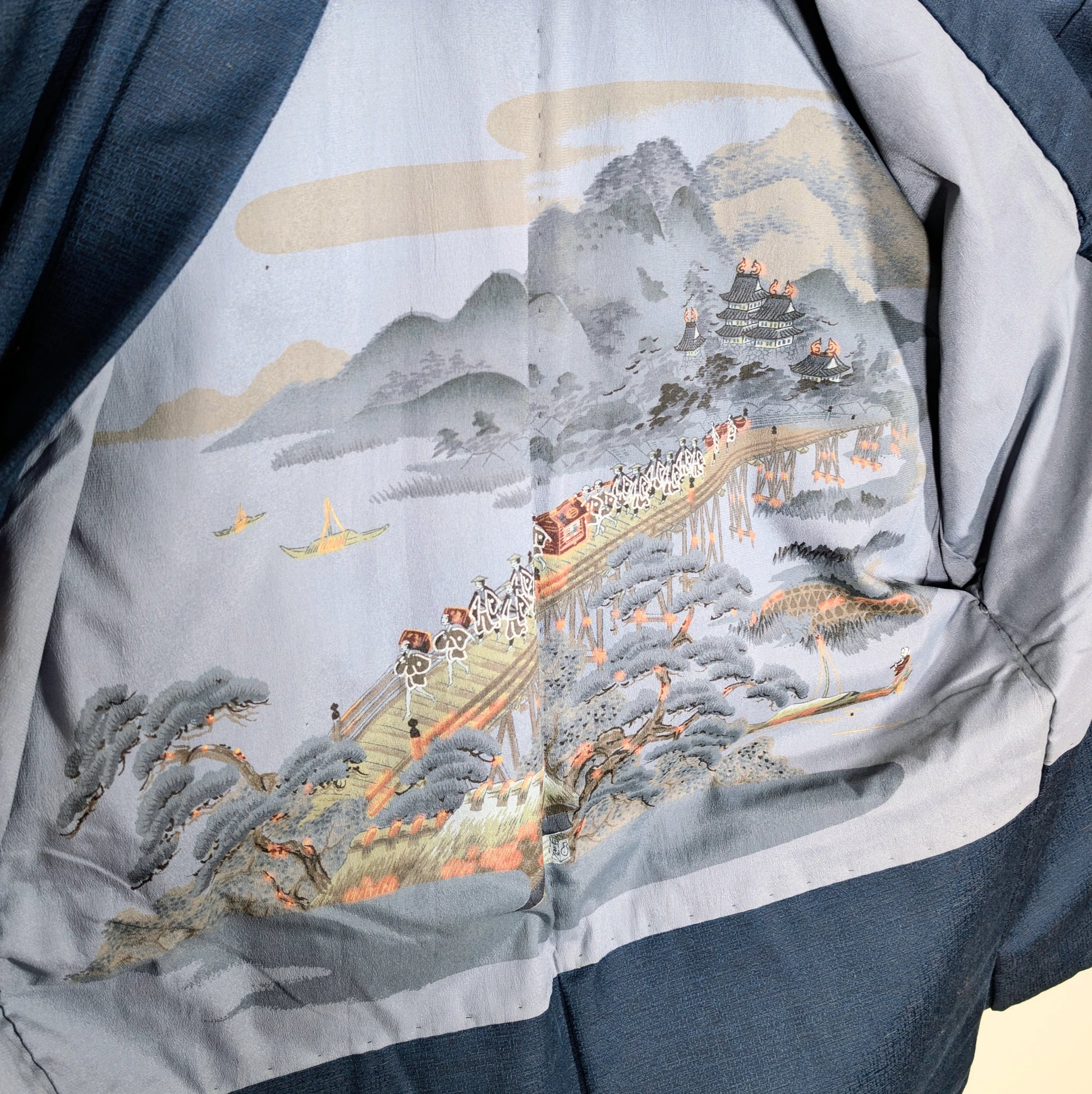 Doublure intérieure d’un haori japonais homme illustrée d’une scène ukiyo-e avec pont, château japonais, montagne et procession traditionnelle