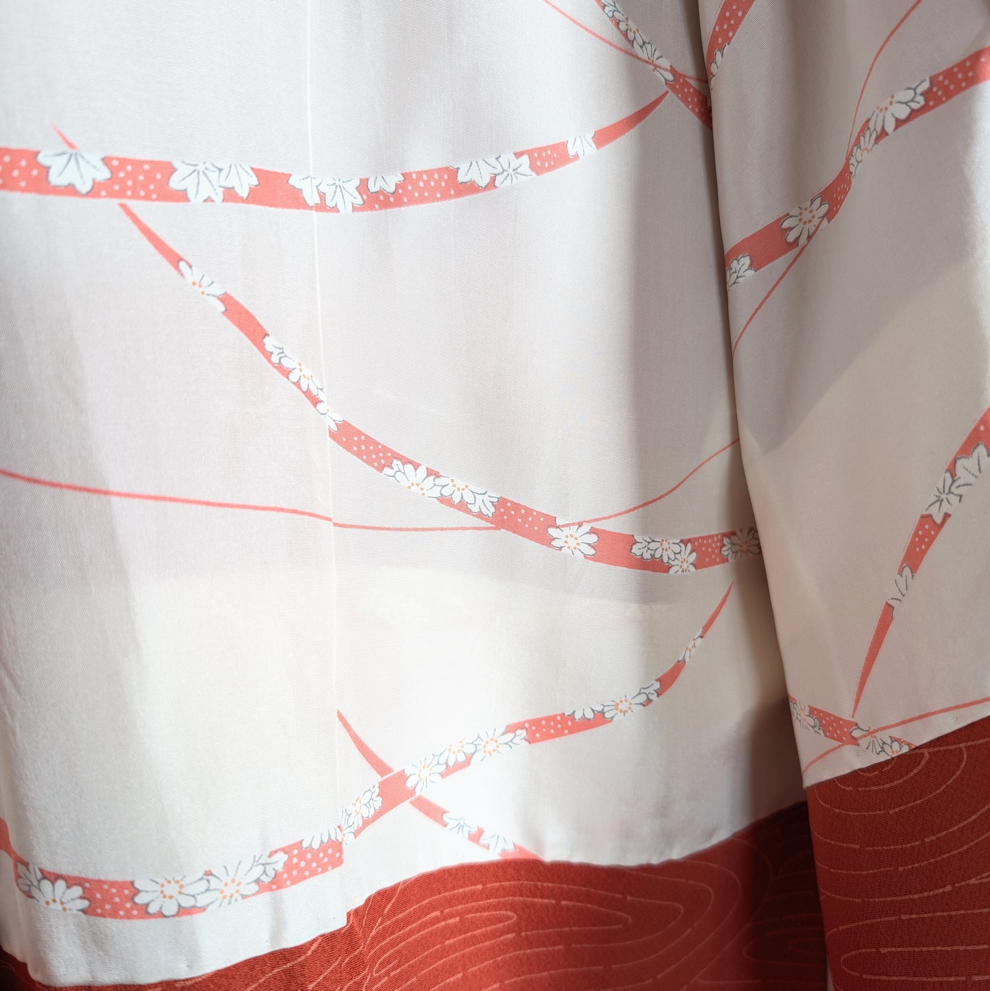 Doublure en soie de haori japonais avec motifs graphiques orange, rubans ondulants et fleurs blanches stylisées