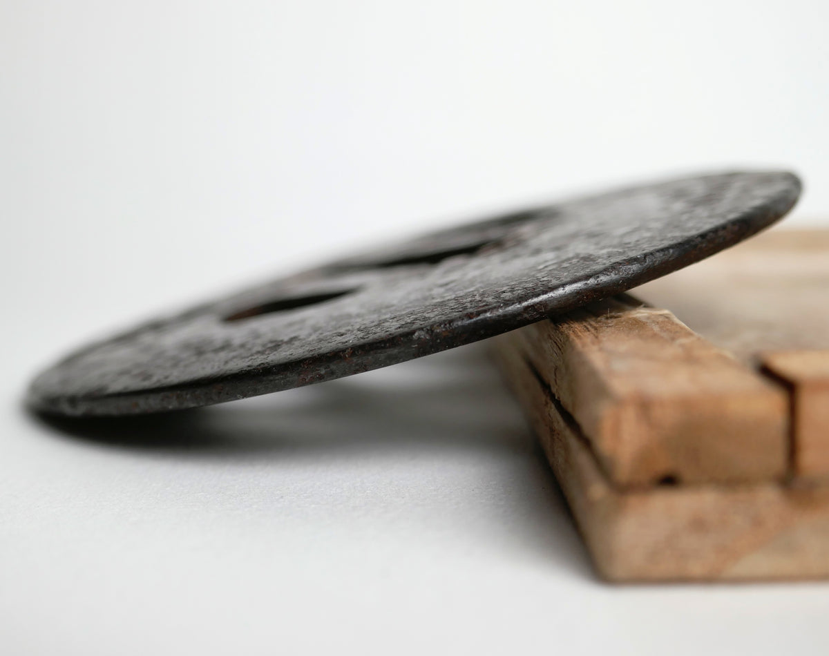 Détail de l’épaisseur et du mimi d’une tsuba ancienne en fer forgé, antiquité japonaise liée au sabre de samouraï.