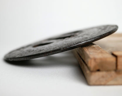 Détail de l’épaisseur et du mimi d’une tsuba ancienne en fer forgé, antiquité japonaise liée au sabre de samouraï.