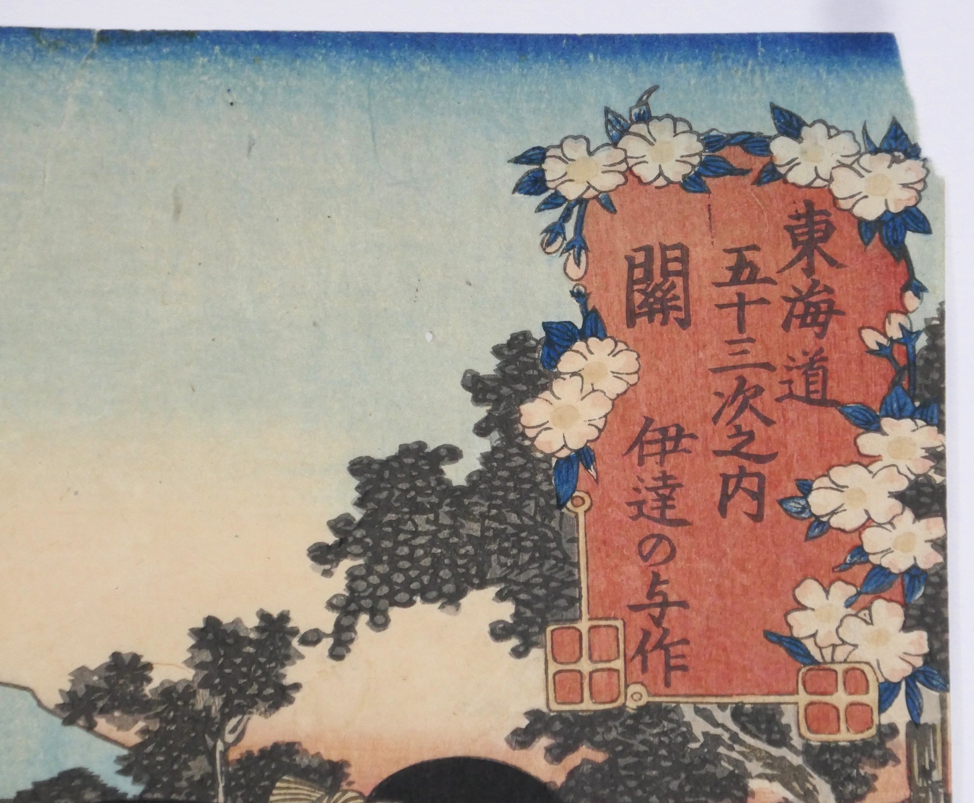 Cartouche de titre décoré de fleurs dans une estampe japonaise, mentionnant la série les 53 stations du Tokaidô