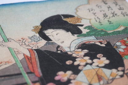 Femme en kimono tenant une rame avec cartouche calligraphié dans une estampe japonaise de Yoshitora scène de hanami