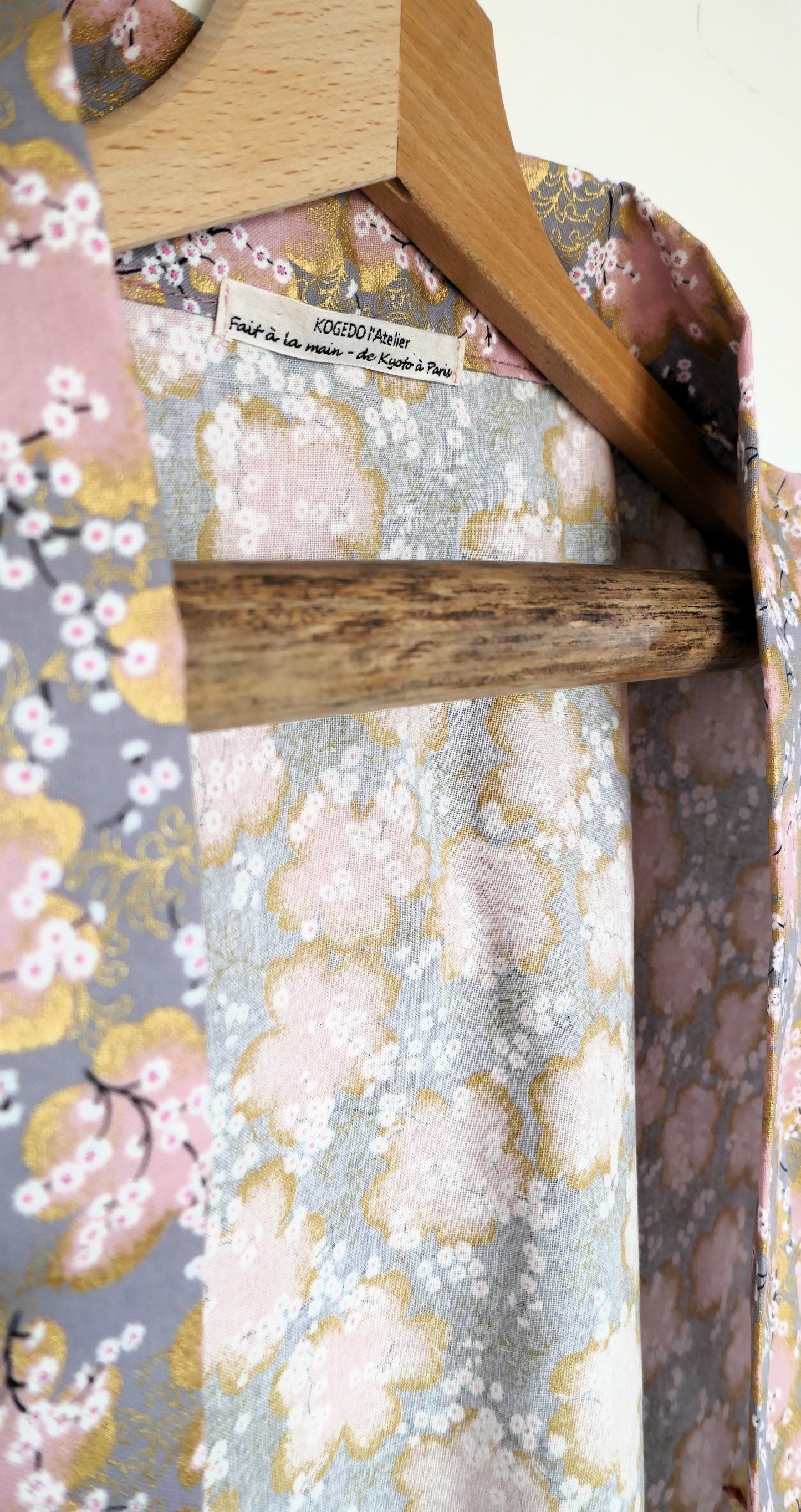 Étiquette du haori Sakura Fubuki, “fait main – de Kyoto à Paris”, sur fond de tissu japonais à fleurs de cerisier