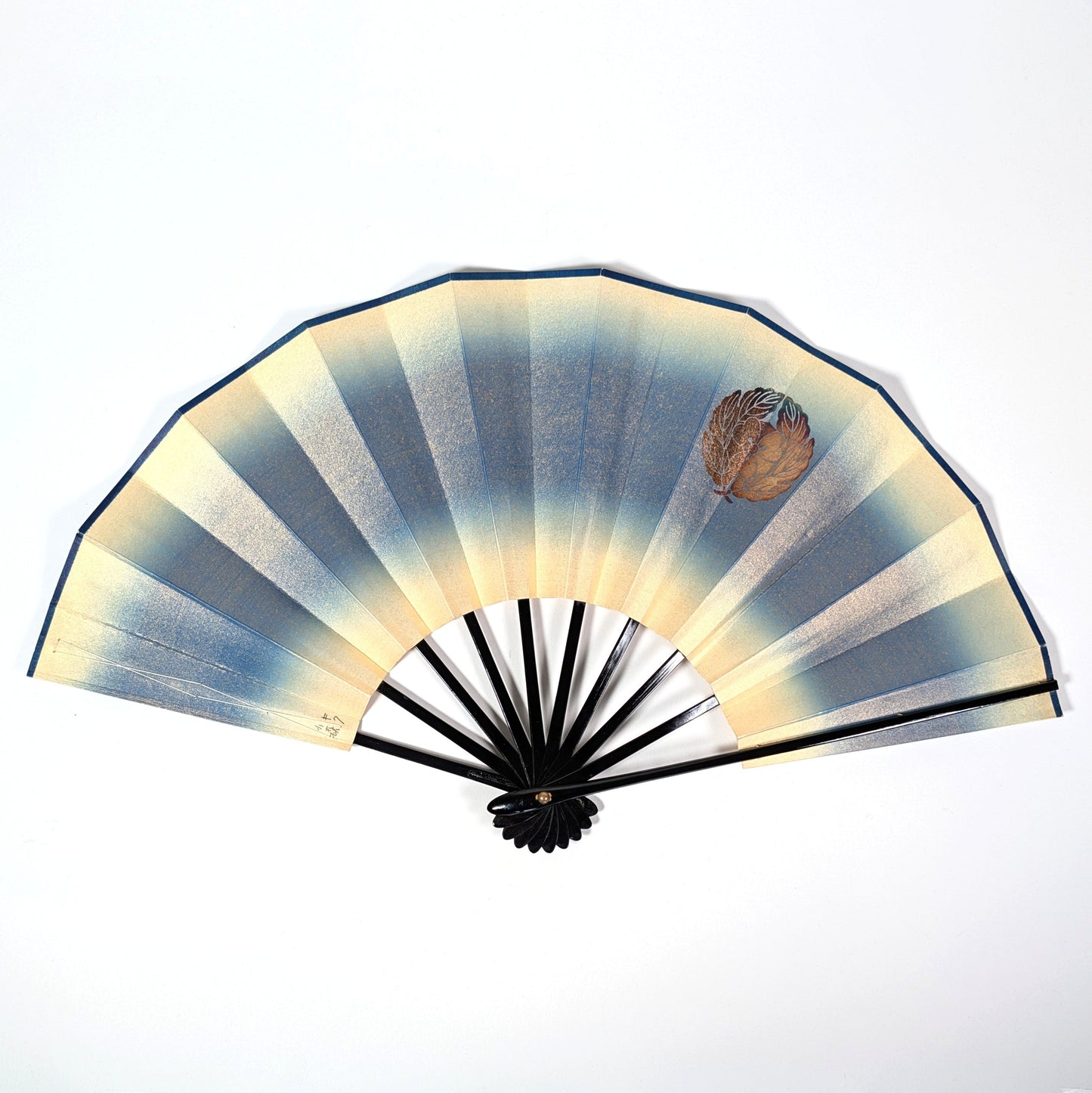 Éventail japonais sensu bleu et or ouvert, décoré d’un kamon floral avec feuilles de chrysanthème et oxalis.