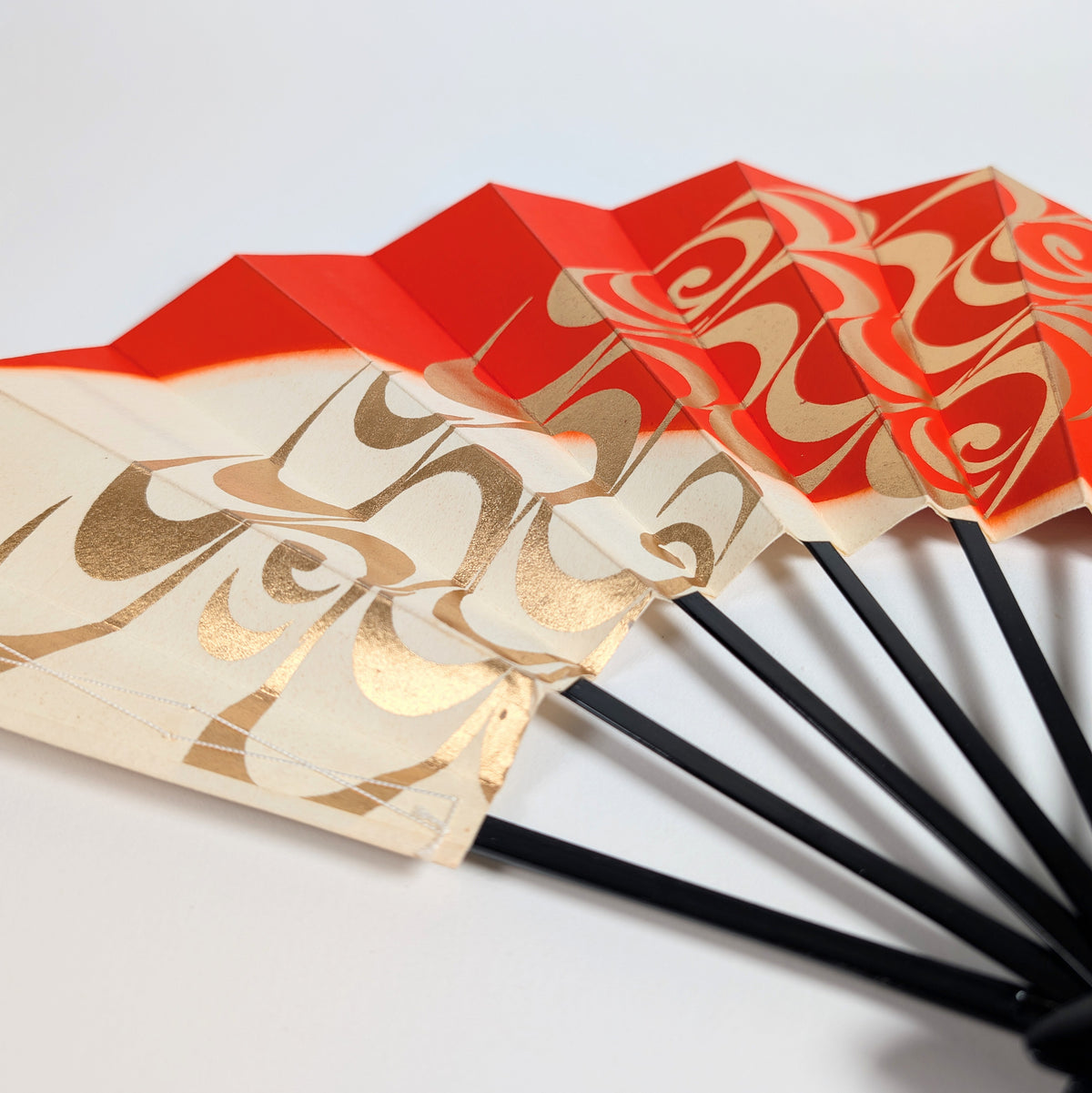 Éventail japonais sensu rouge vermillon, ivoire et or avec motif ryūsui stylisé en volutes d’eau