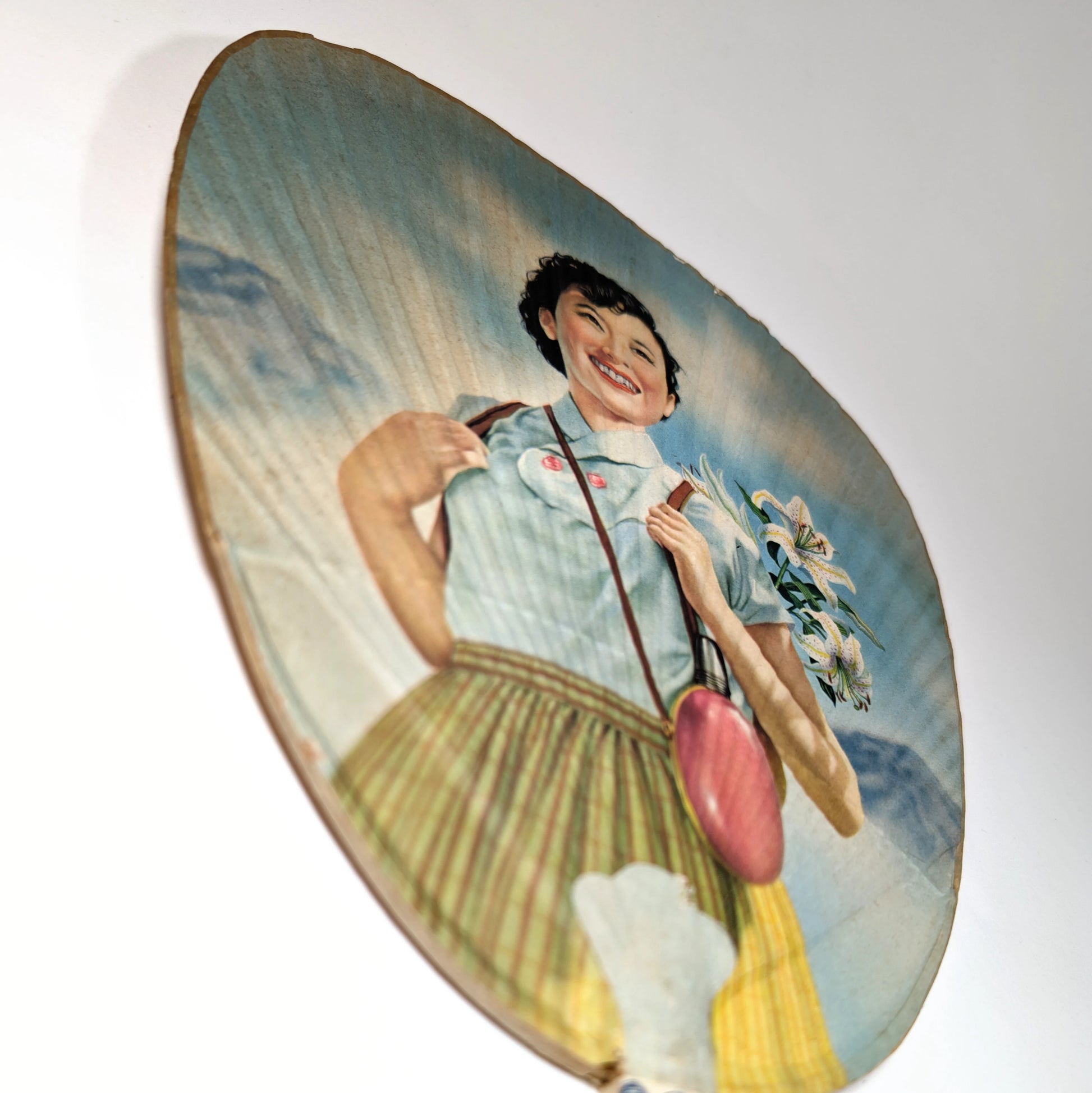 vue en perspective d’un éventail uchiwa vintage japonais montrant les reliefs du papier et l’illustration colorée