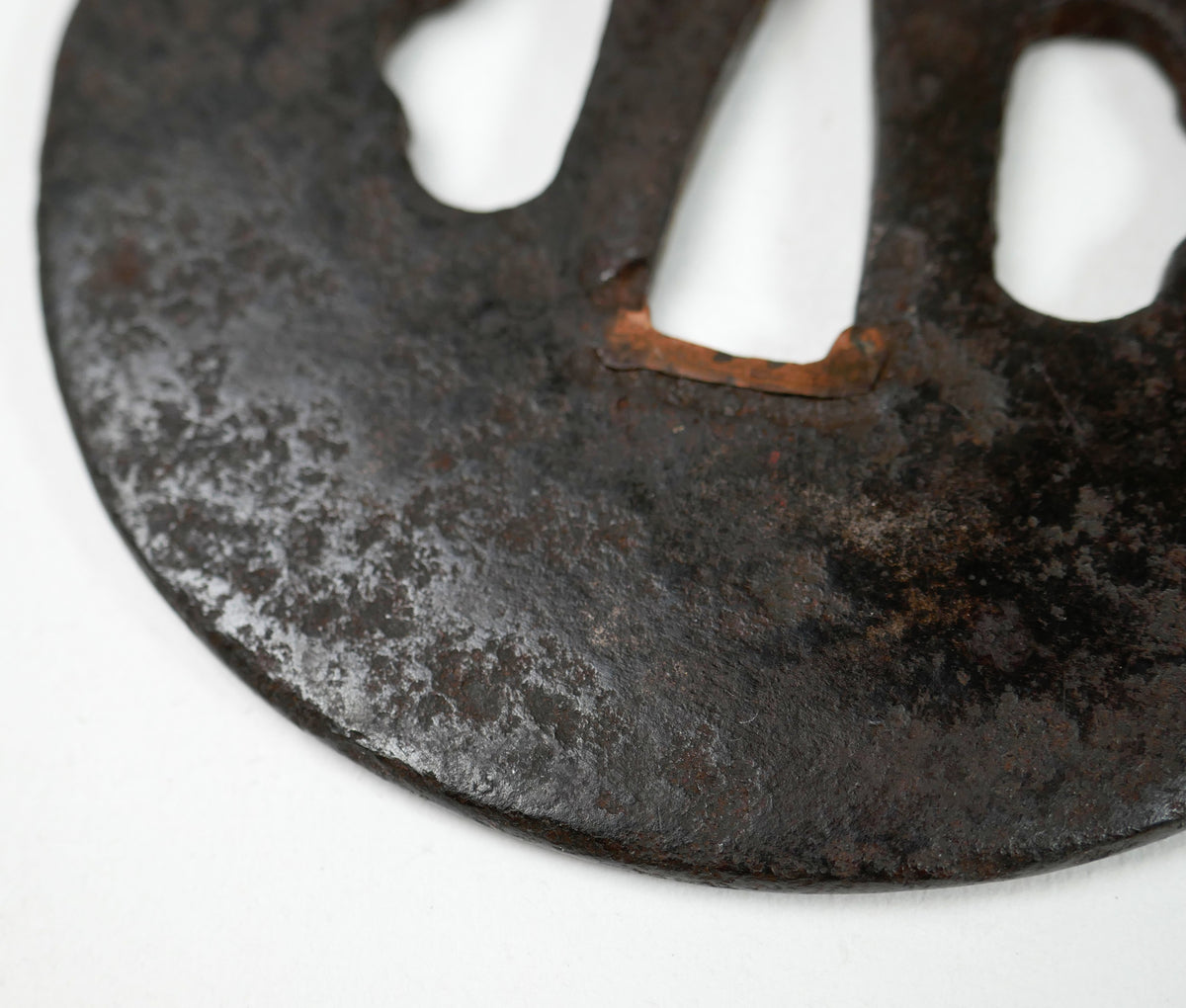 Détail du fer forgé, de la patine et du mimi d’une ancienne tsuba Ko-Tōshō, garde de sabre japonais de collection.