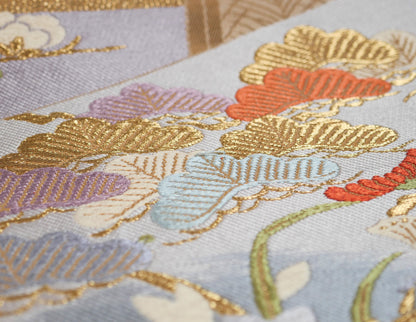 Motifs de pins matsu bleu ciel, mauve, corail et or sur un fukuro obi japonais en brocart de soie