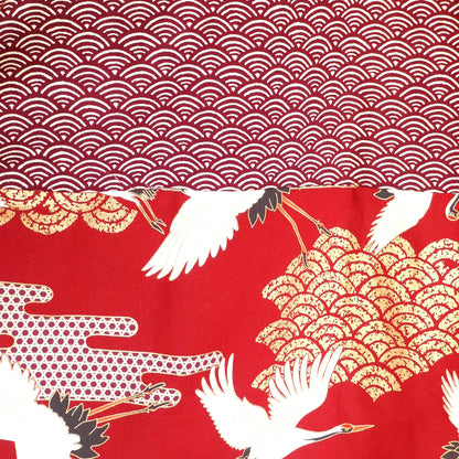 Détail de l’empiècement dos du haori Akane Tsuru, avec grues blanches volant au-dessus de vagues dorées sur fond rouge profond.