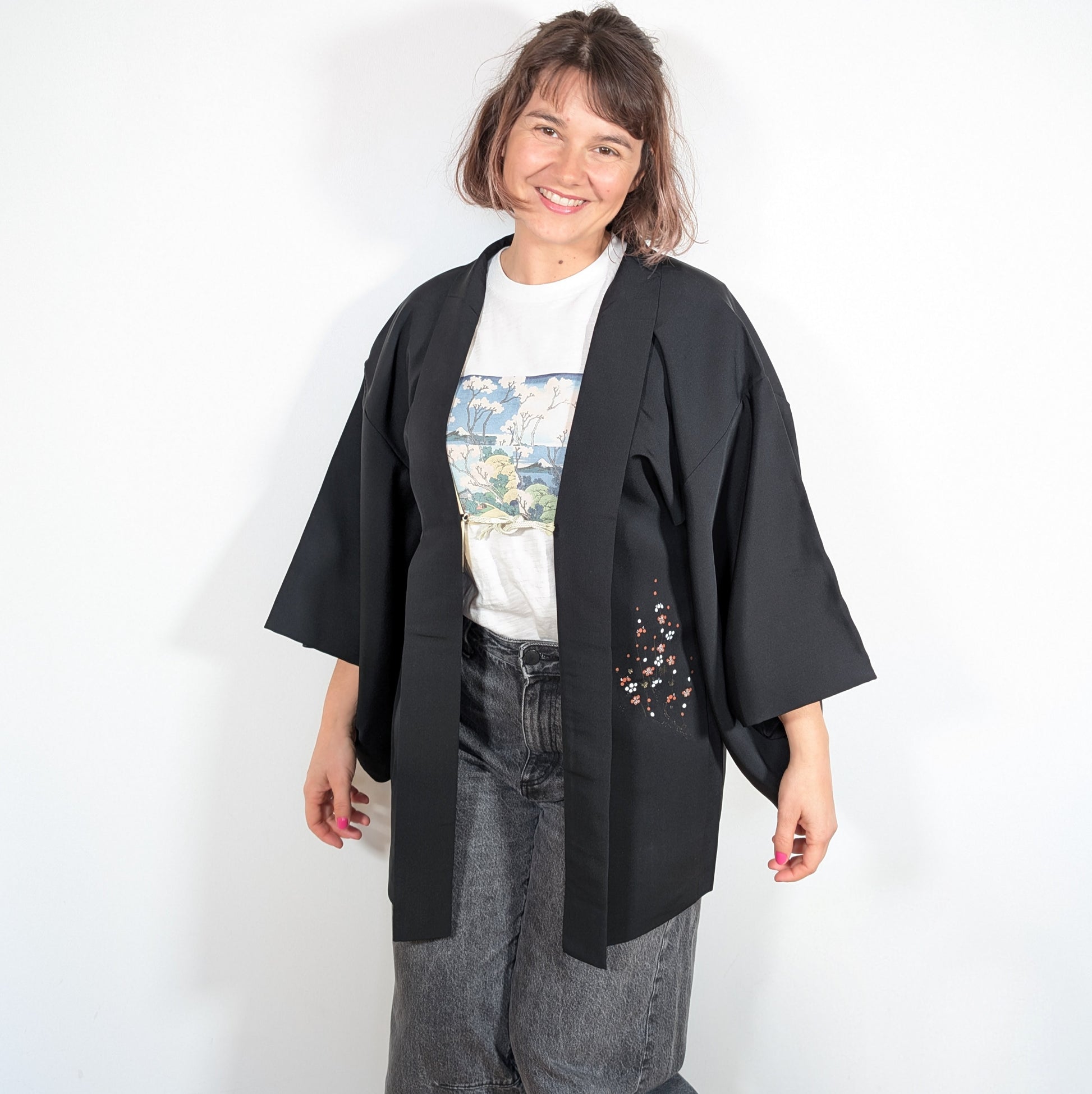 Haori femme vintage en soie shōken porté par Mikan, veste kimono noire avec motif floral japonais ume rouge blanc et doré.