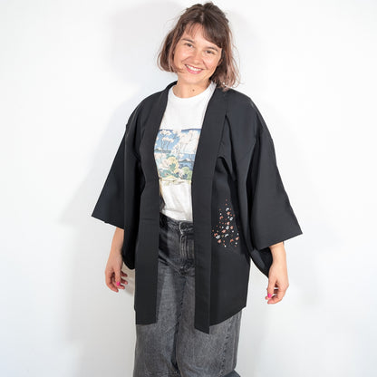 Haori femme vintage en soie shōken porté par Mikan, veste kimono noire avec motif floral japonais ume rouge blanc et doré.