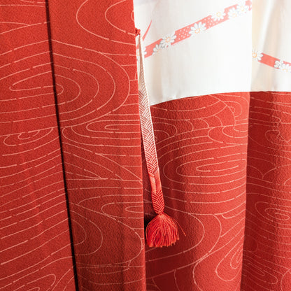 Détail du haori himo à pompon orange sur veste kimono japonaise en soie chirimen avec motif ryusui