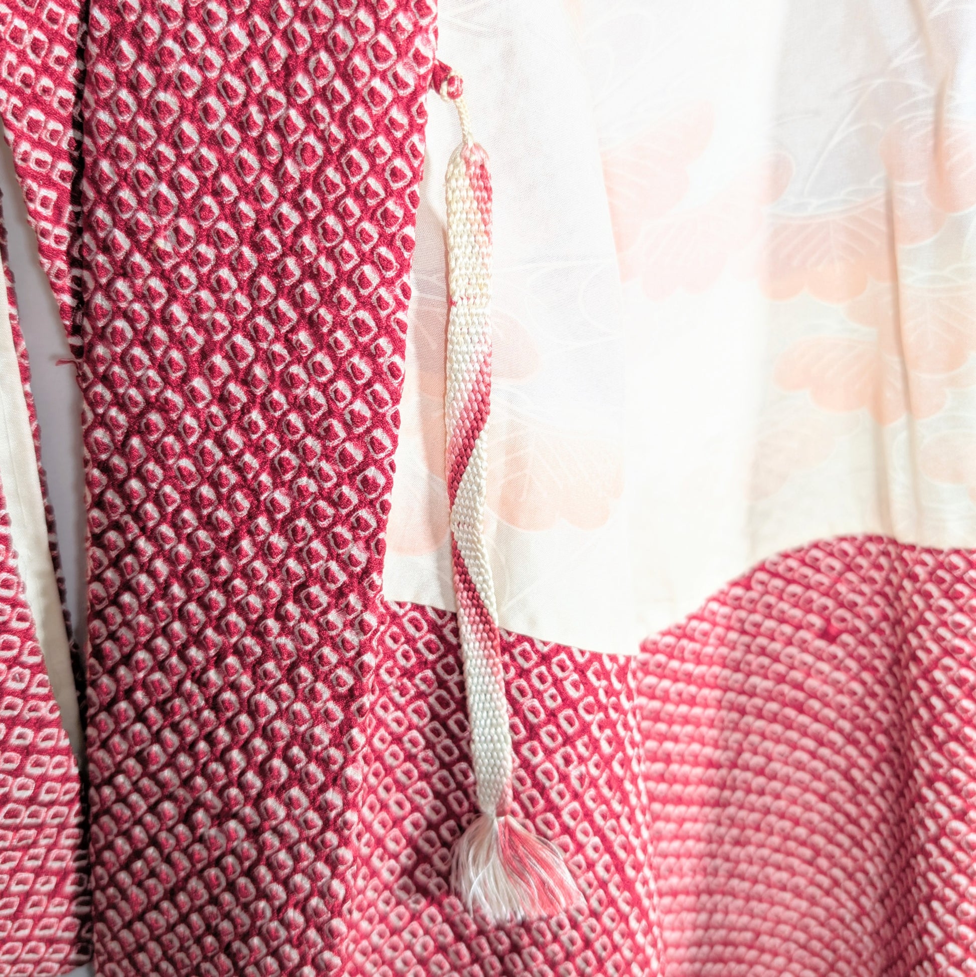 Haori himo traditionnel en soie attaché à une veste kimono shibori rouge, détail authentique du Japon