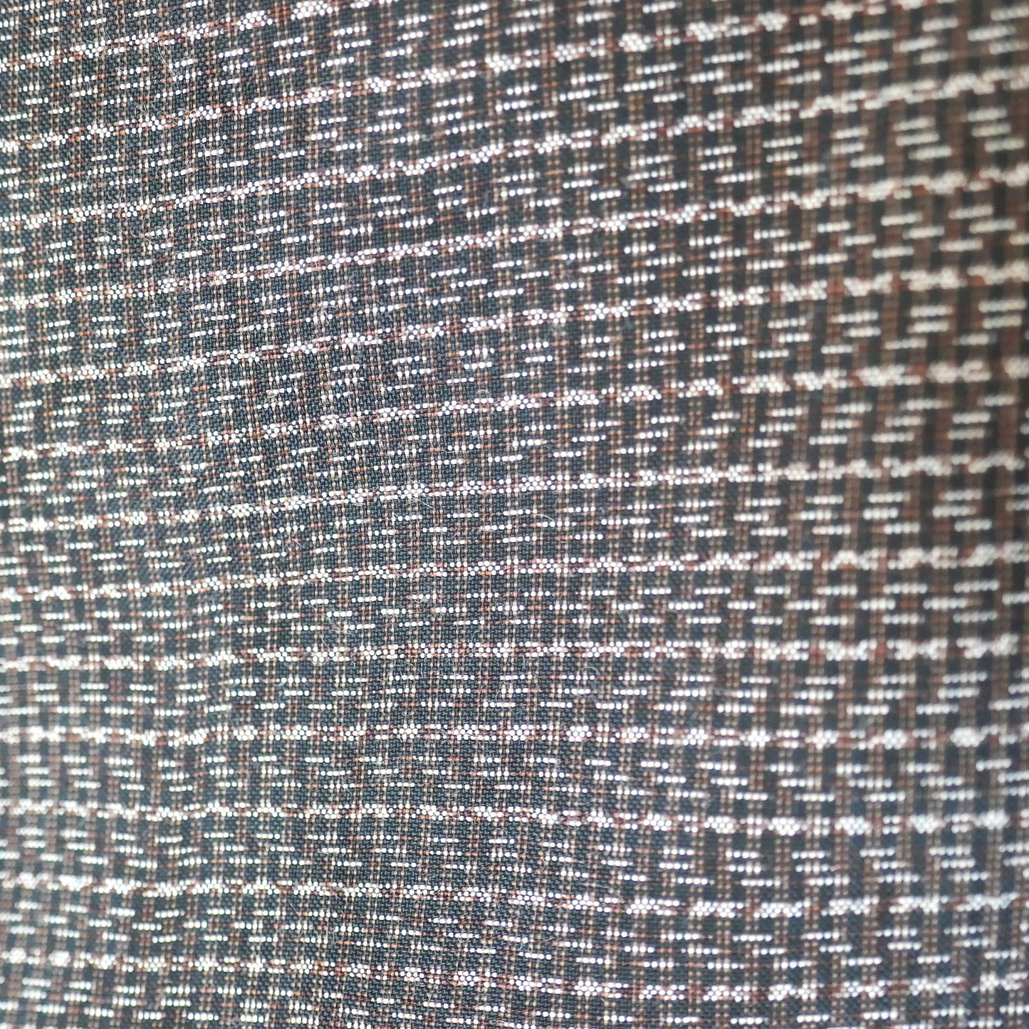 Détail du tissage en laine et soie d’un haori homme japonais – motif discret inspiré de yagasuri 矢絣 sur fond brun foncé.