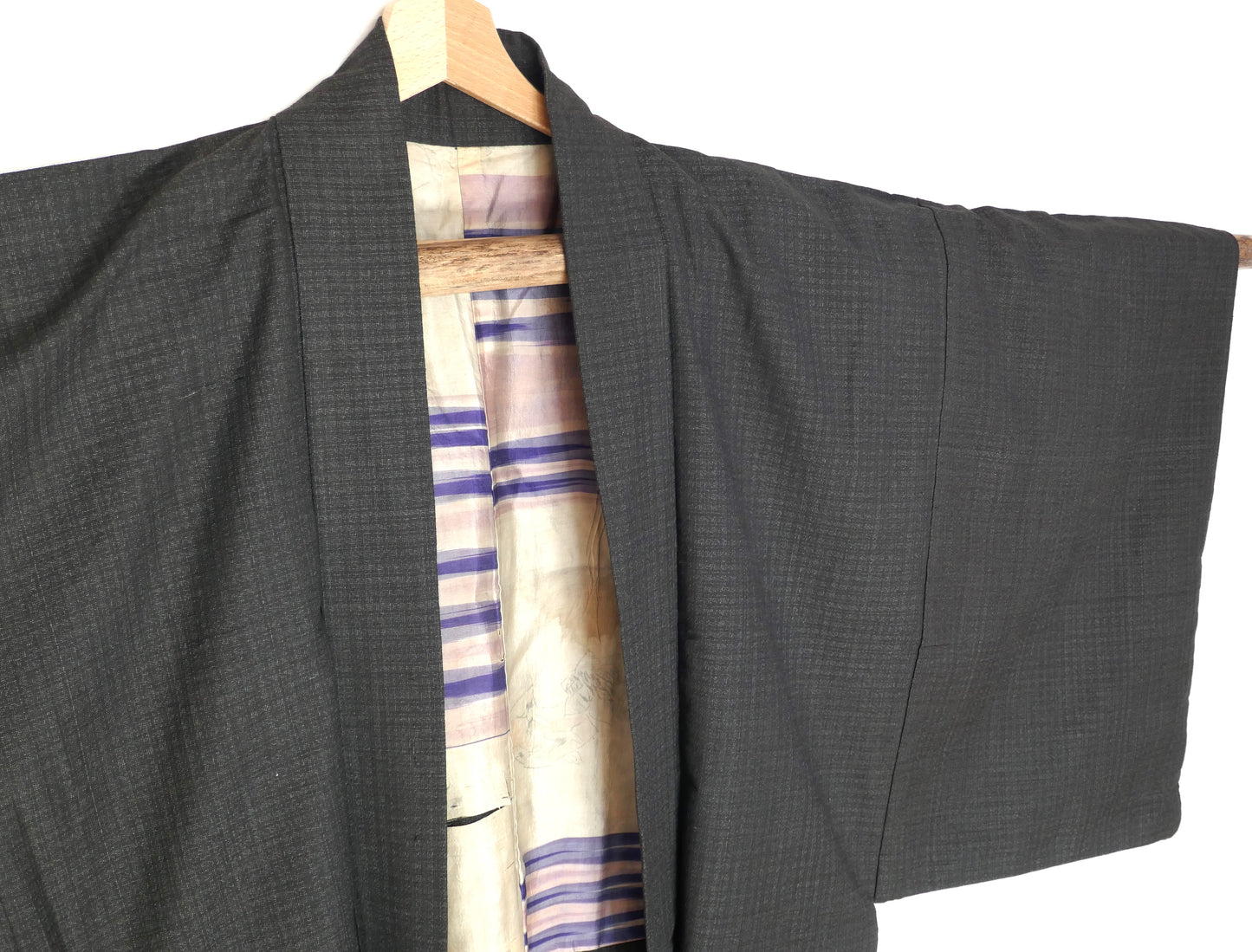Vue en angle gauche d’un haori homme japonais ancien, laine gris foncé à motifs fins.