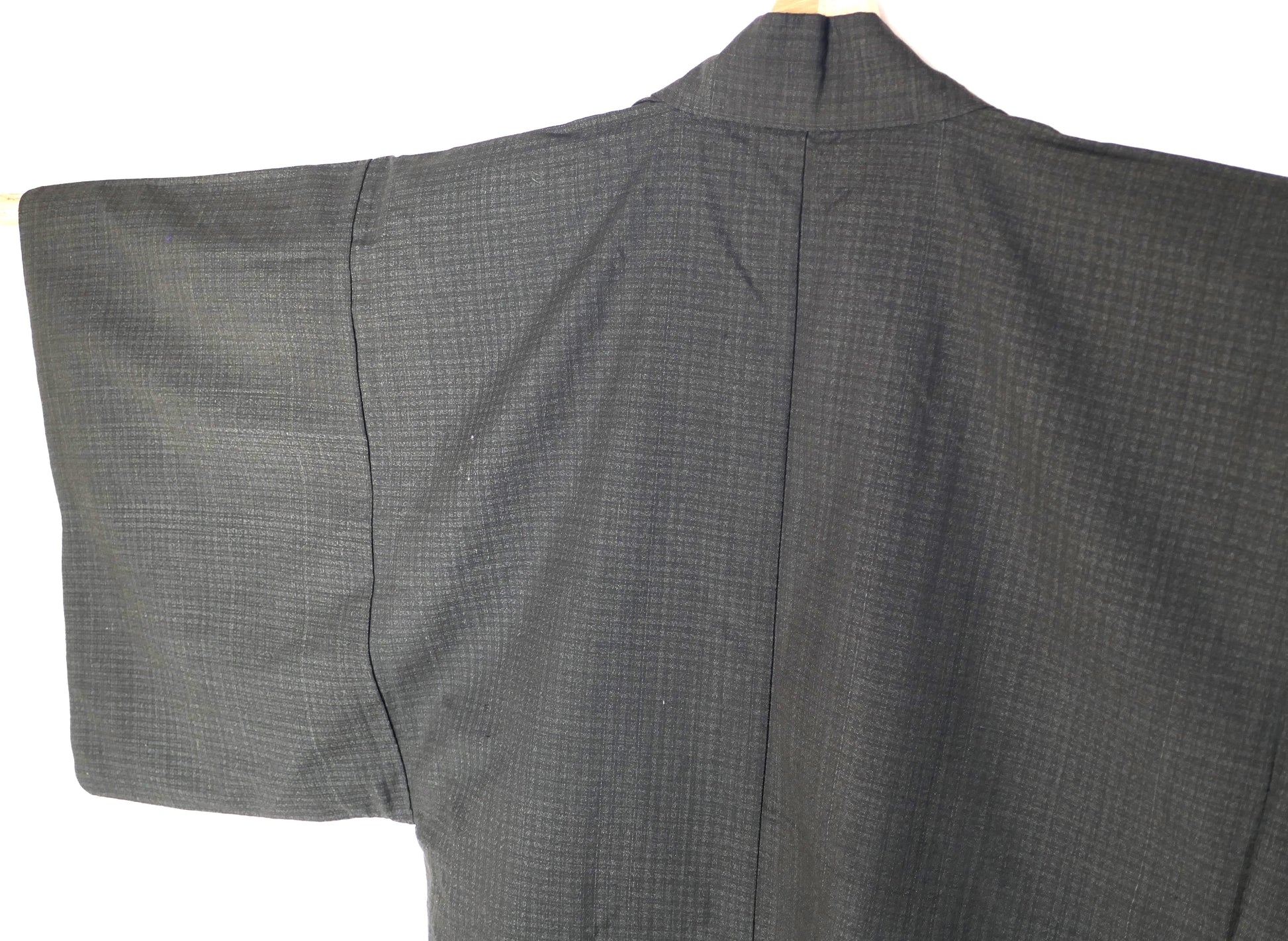 Détail du dos d’un haori japonais pour homme, tissage discret sur fond gris anthracite.