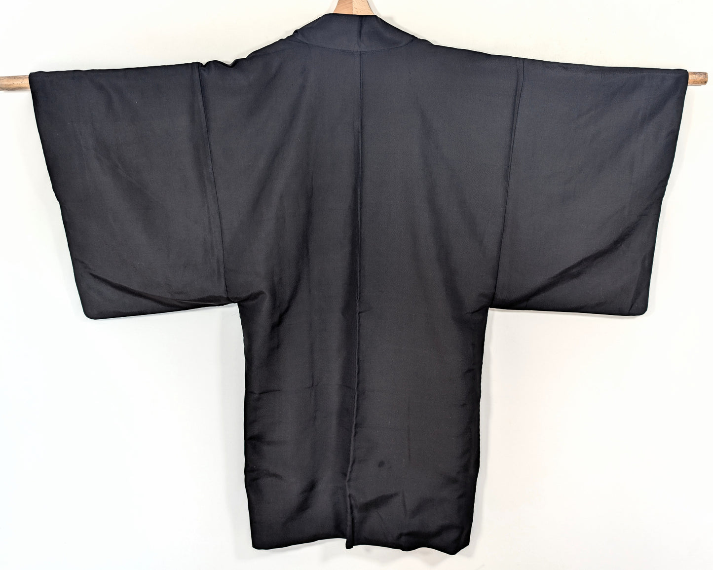 Vue de dos d’un haori long pour homme en soie noire, veste japonaise traditionnelle sobre et élégante