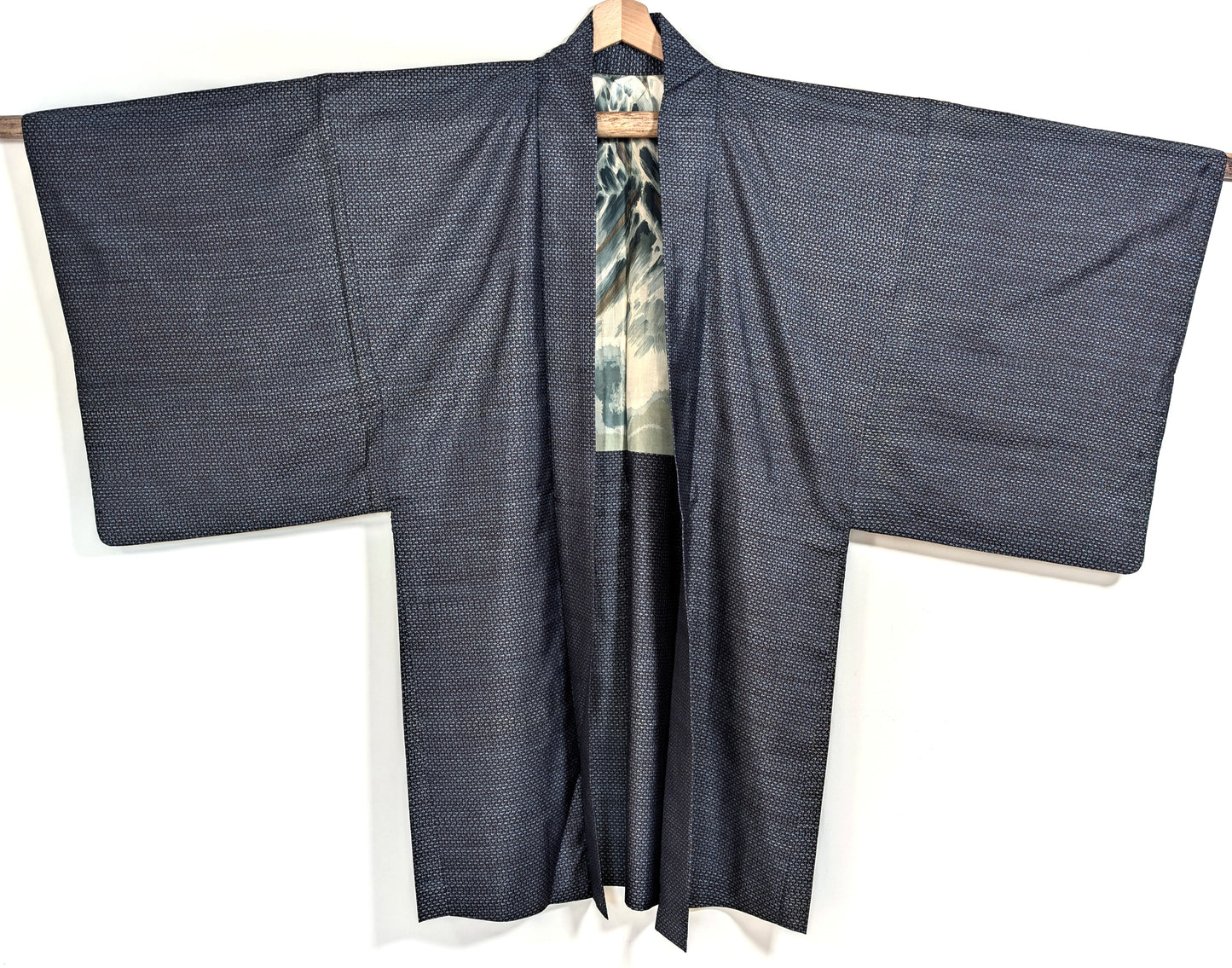 Haori homme en soie Ōshima Tsumugi bleu ouvert sur une doublure katazome au mont Fuji avec vagues et rehauts dorés appliqués à la main