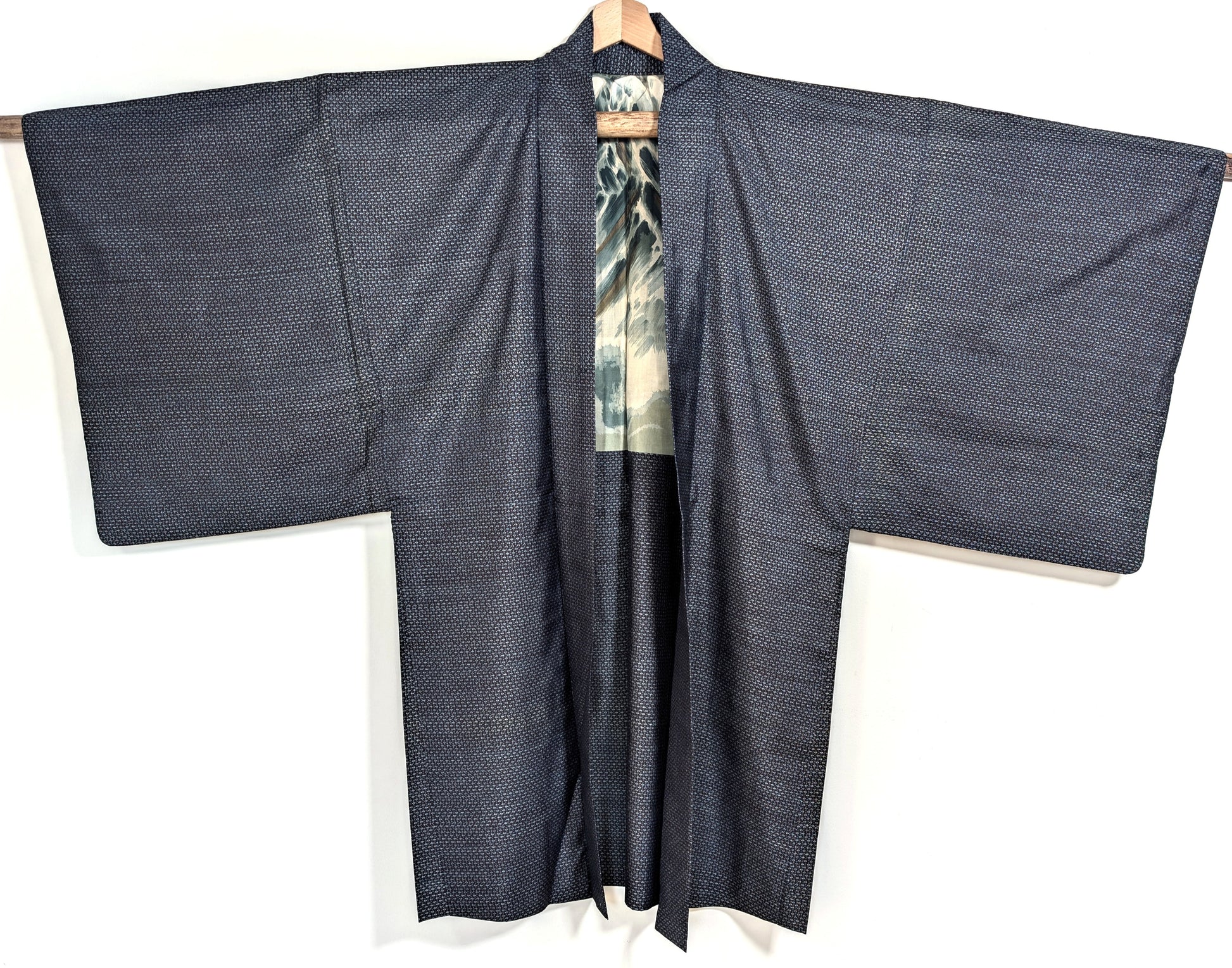 Haori homme en soie Ōshima Tsumugi bleu ouvert sur une doublure katazome au mont Fuji avec vagues et rehauts dorés appliqués à la main