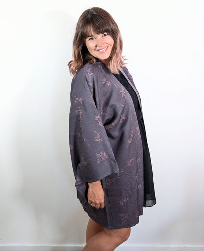 Femme portant un haori japonais en soie violet grisé à motif nanten rose, veste kimono traditionnelle