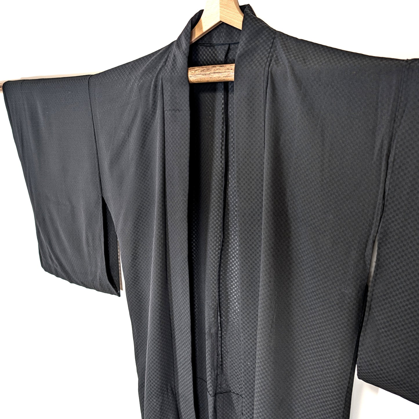 Haori japonais léger en soie noire monsha à motif ichimatsu, détail du col et des larges manches traditionnelles.