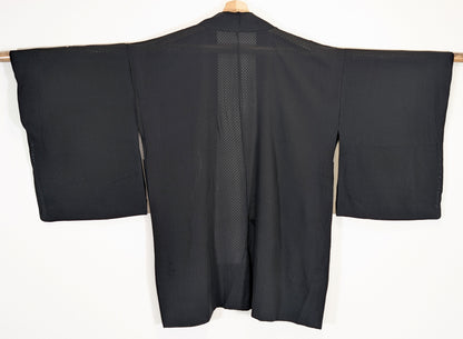 Vue de dos d’un haori japonais léger de type usubaori en soie noire monsha, étoffe transparente à damier ichimatsu.