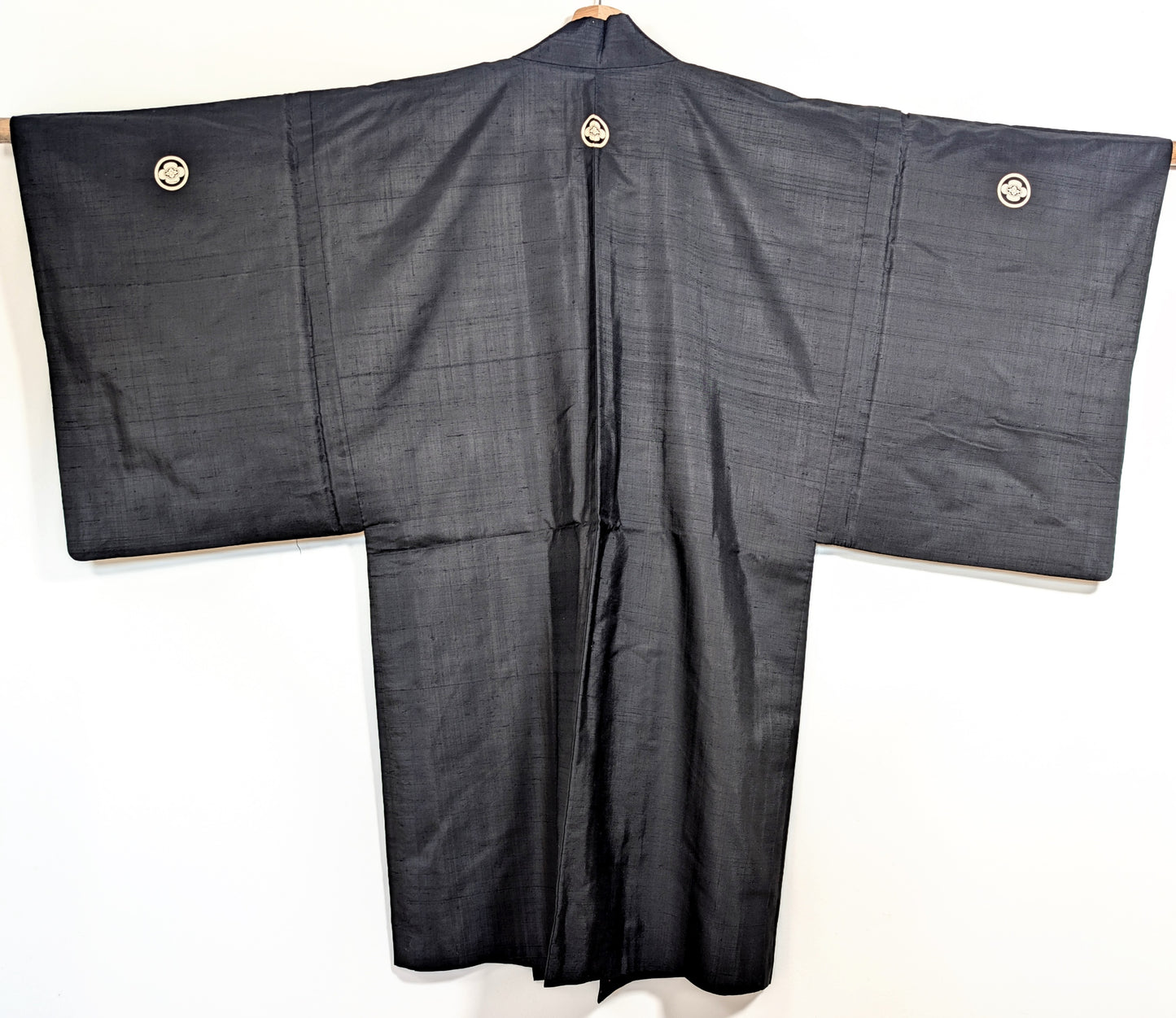 Dos d’un haori japonais noir en soie, veste traditionnelle montsuki avec kamon maru mokkō