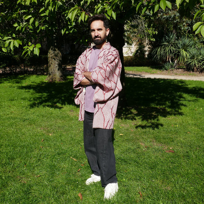 Tôma en veste kimono traditionnelle haori vintage japonais en soie, motif shibori rouge grenat, dans un parc à Paris.