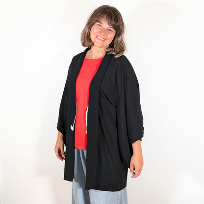 Haori japonais authentique en soie noire monsha porté sur une tenue contemporaine, veste kimono légère à motif ichimatsu.