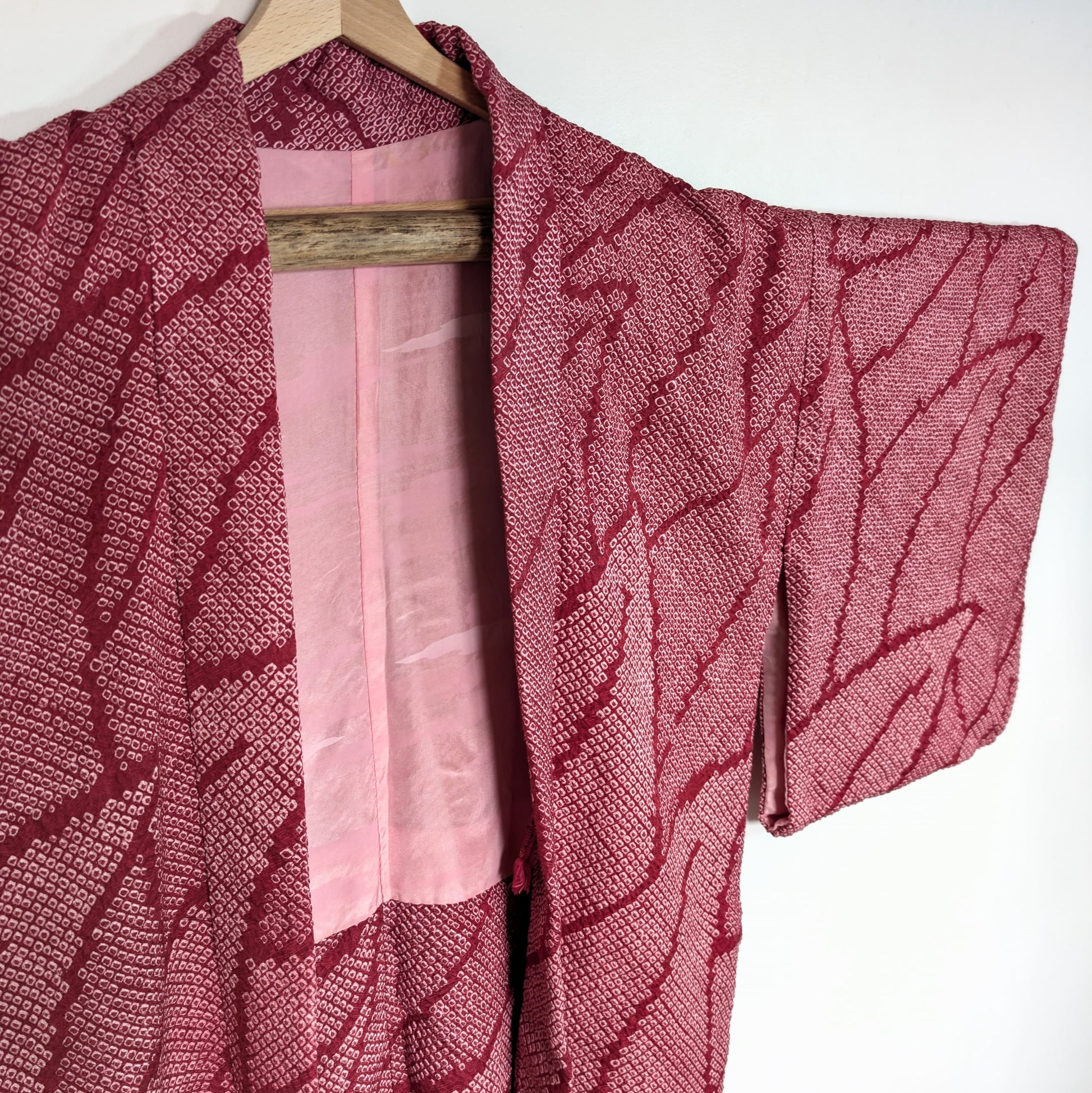 Haori japonais pour femme en soie shibori rose fuchsia, motif feuillage stylisé et doublure intérieure à motif nuages.