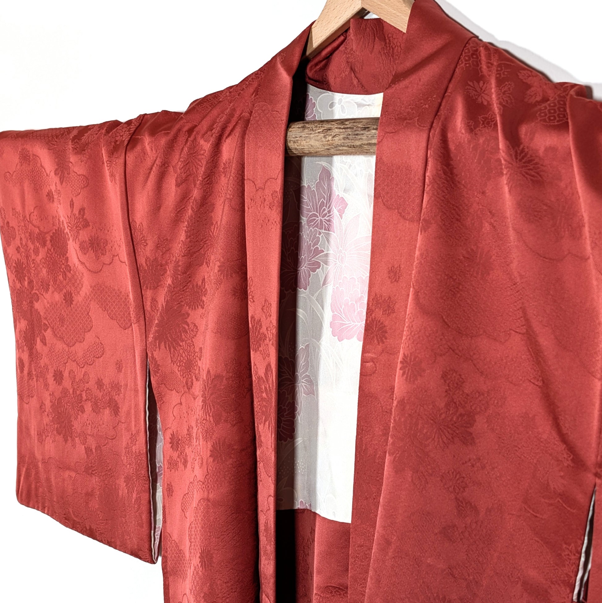 Vue avant d’un haori japonais ancien en soie terracotta avec motifs floraux traditionnels et coupe kimono