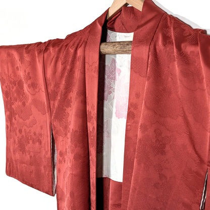 Vue avant d’un haori japonais ancien en soie terracotta avec motifs floraux traditionnels et coupe kimono