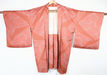 Haori japonais vintage en soie chirimen rose terracotta avec motifs graphiques et vagues seigaiha vue de face