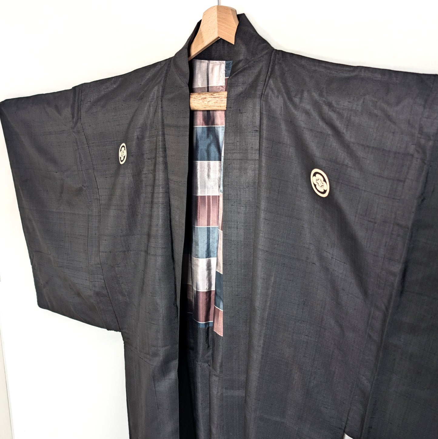 Haori japonais vintage en soie noire avec doublure traditionnelle visible à l’ouverture