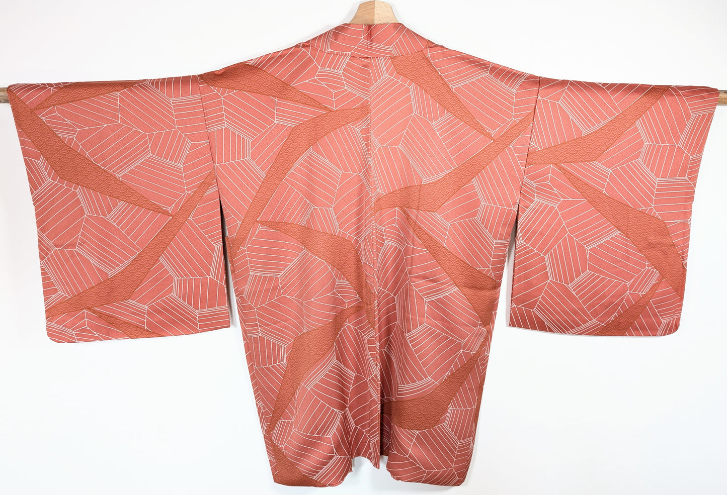 Vue dos d’un haori japonais en soie chirimen rose terracotta avec motifs seigaiha et design géométrique élégant