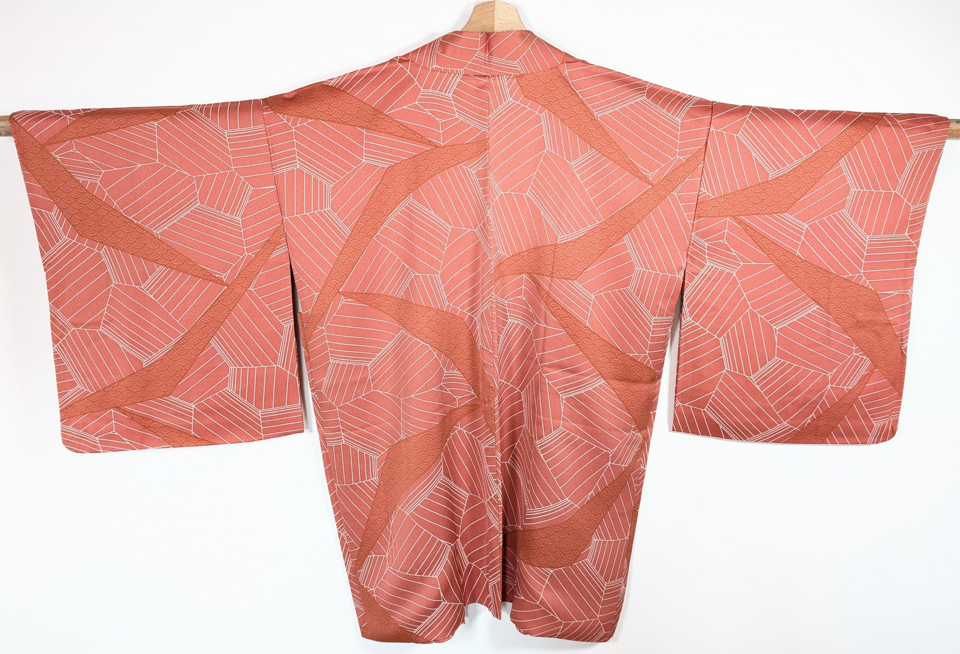 Vue dos d’un haori japonais en soie chirimen rose terracotta avec motifs seigaiha et design géométrique élégant