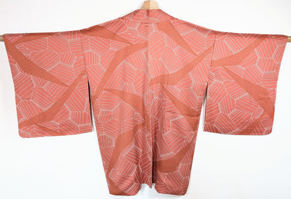 Vue dos d’un haori japonais en soie chirimen rose terracotta avec motifs seigaiha et design géométrique élégant