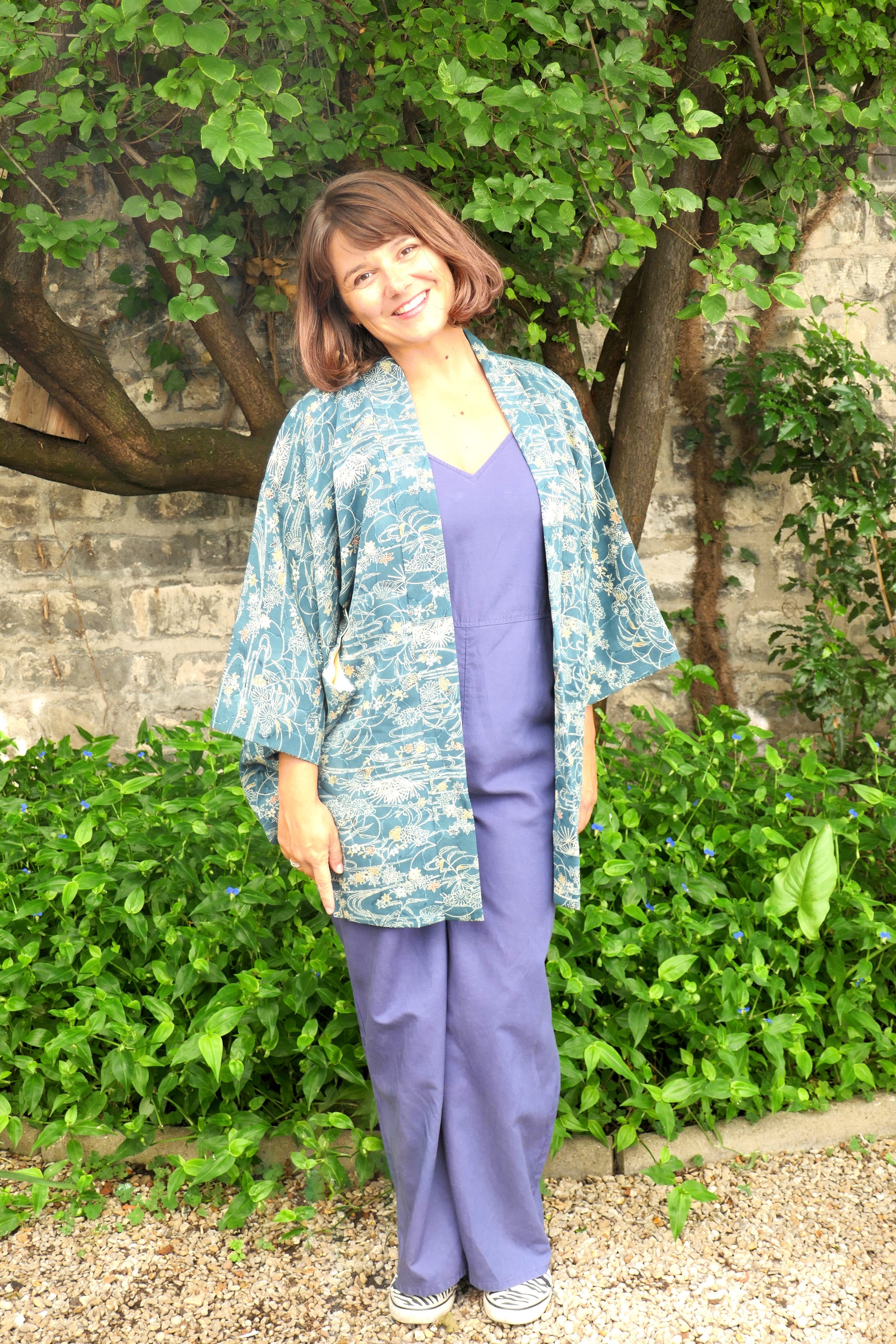 Femme souriante portant un haori japonais vintage à motif aquatique – style détente en extérieur