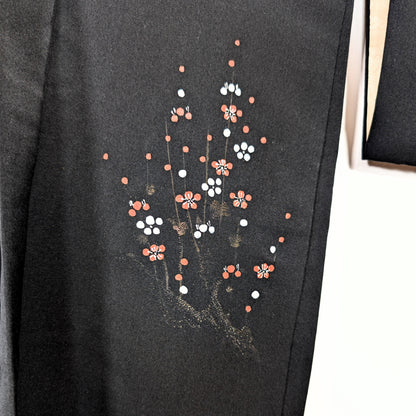 Détail du motif ume sur haori noir chic, fleurs de prunier rouges et blanches avec branches dorées sur soie japonaise.