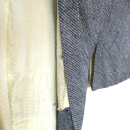 Gros plan sur l’attache intérieure haori himo d’un haori en soie, avec aperçu de la doublure à motifs d’éventails.