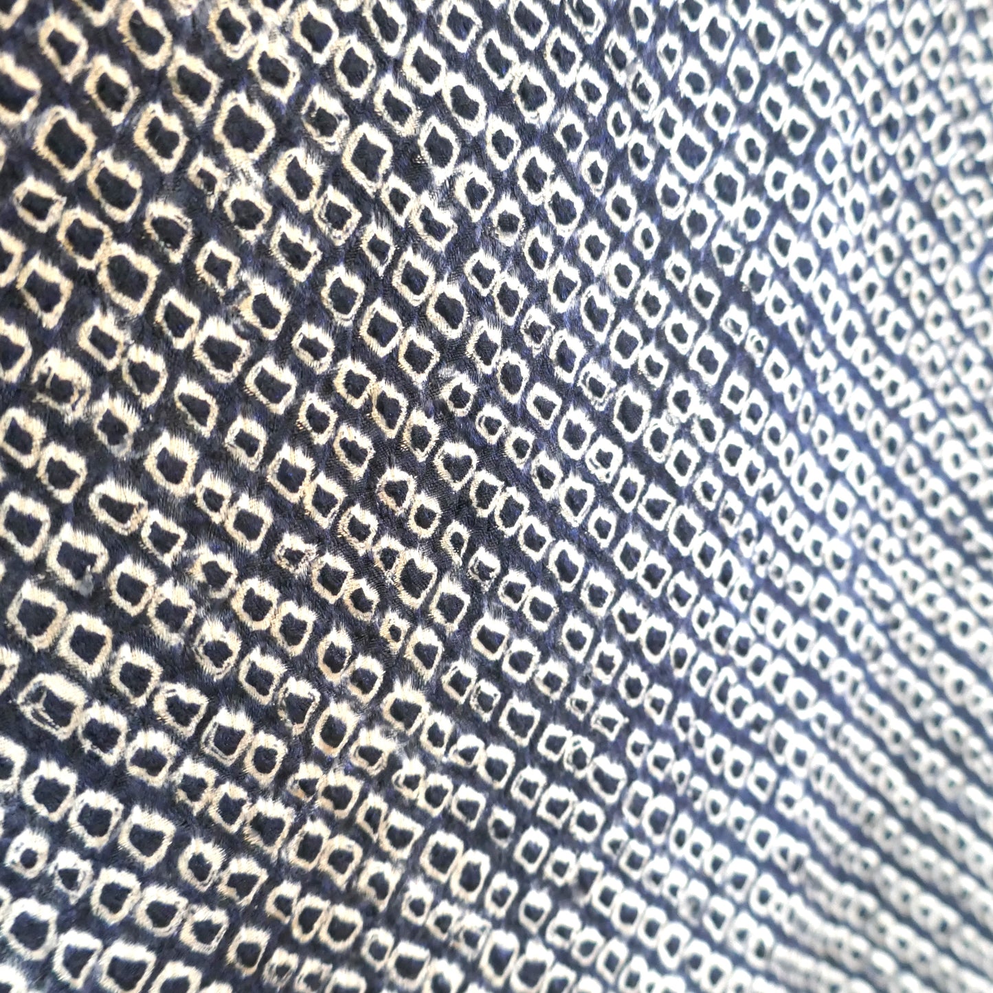 Gros plan sur le motif shibori bleu nuit d’un haori vintage japonais en soie.