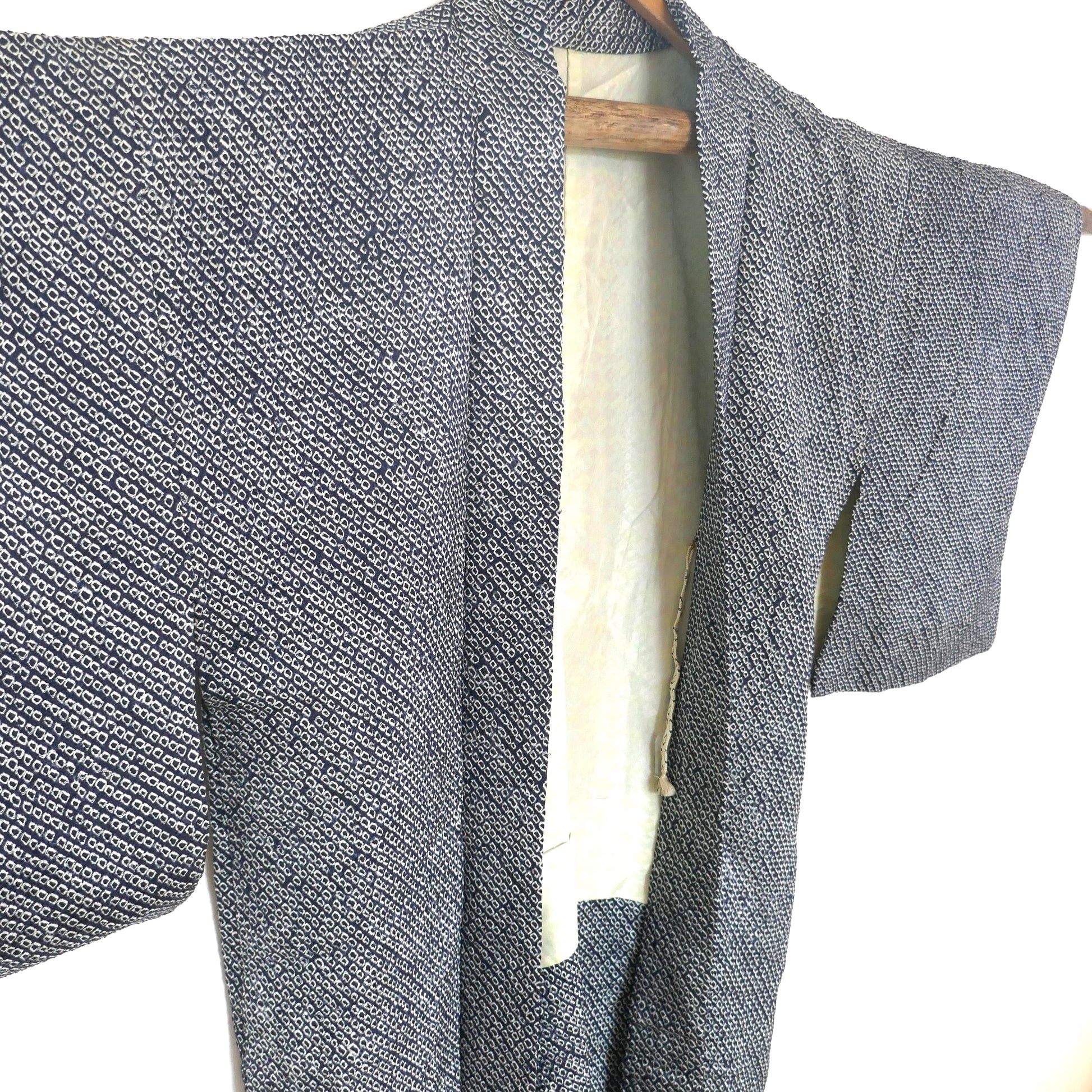 Gros plan sur l’avant gauche du haori en shibori bleu nuit avec col ouvert et doublure visible.