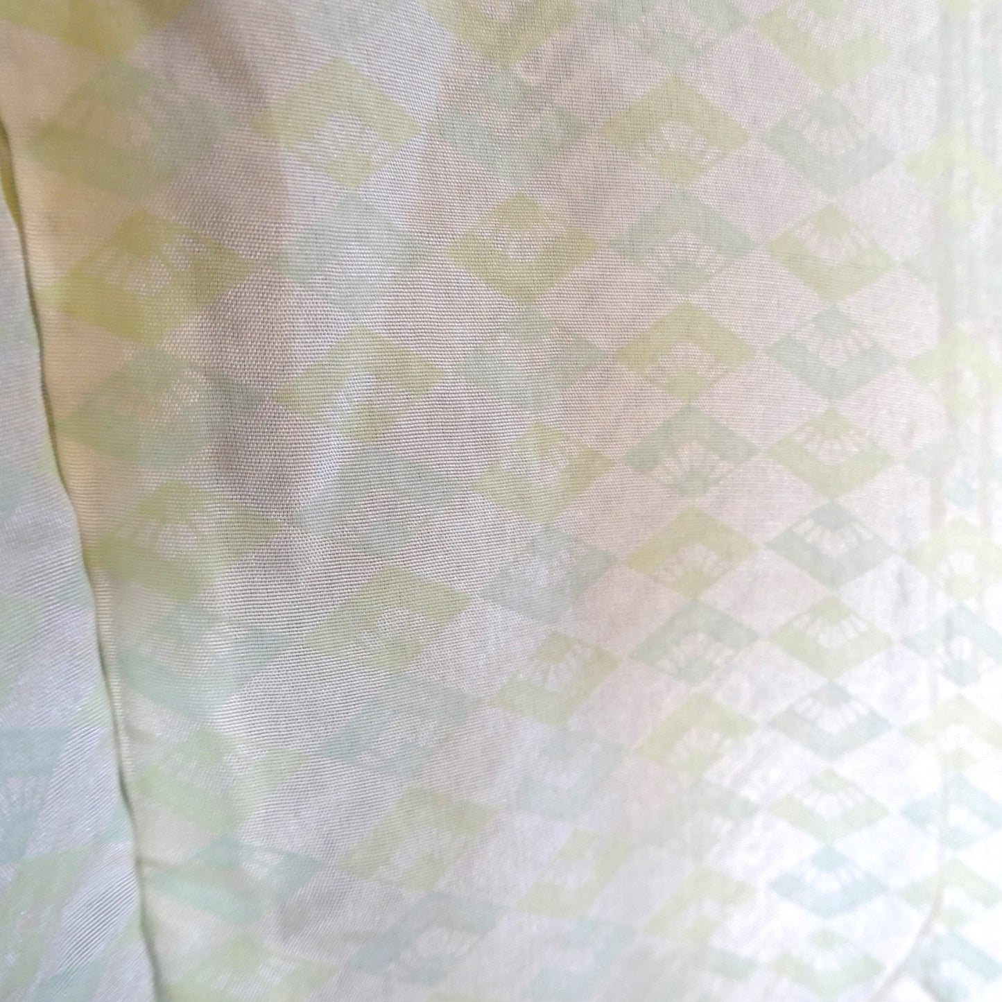 Détail de la doublure en soie ivoire d’un haori vintage, décorée de motifs d’éventails japonais.